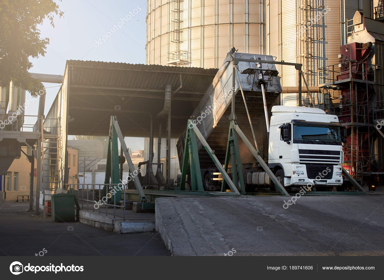 Unloading grain truck at elevator on elevating hydraulic platform