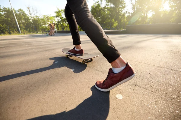 Close-up van skateboarders voeten tijdens het schaatsen in Skatepark. Man rijden op een skateboard. Geïsoleerd beeld, lage hoek schoot. — Stockfoto