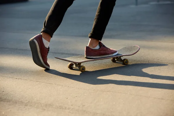 Primer plano de los pies de los patinadores mientras patinan en el parque de skate. Hombre montando en monopatín. Vista aislada, plano de ángulo bajo . — Foto de Stock