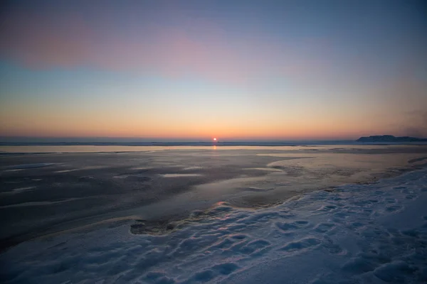 Dondurulmuş deniz günbatımı üzerinde. Kış zamanında güzel doğal deniz manzarası. Ufuk için sonsuz buz. Buz yüzeyi ürün yerleştirme. — Stok fotoğraf