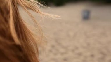 Kırmızı kadın saç ihale hareketi yavaş çekimde havada arka görünümü kapatın. Kumsalda yürüyen Redhaired kadın. Sunset bulvarında güneşte parlayan havadar kızıl saçlarını Rüzgar esiyor. Makro video.