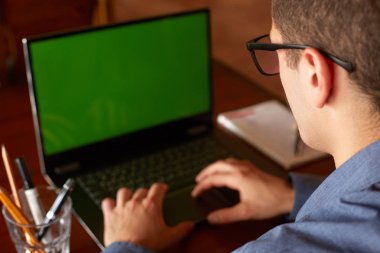 Arkadan görünüşü serbest meslek sahibi adam gözlüklü laptop ile çalışma. Yeşil ekran. Beyaz iş adamı projesi PC yapıyor. Boşaltmak ve ürün yerleştirme.