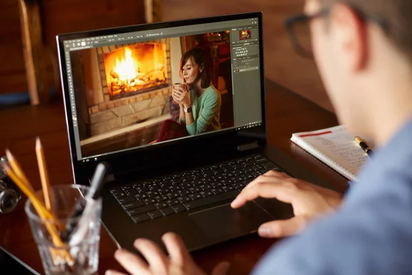 L'uomo ritoccatore freelancer lavora al computer portatile con software di redazione di fotografia. Fotografo o designer al lavoro. Elaborazione digitale delle immagini. Tracciamento e scatto rivelatore — Foto Stock