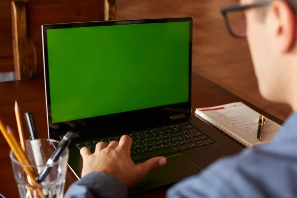 Vista posteriore di uomo libero professionista in occhiali che lavorano con computer portatile. Schermo verde. Uomo d'affari caucasico che fa progetti su pc. Copyspace e product placement . — Foto Stock