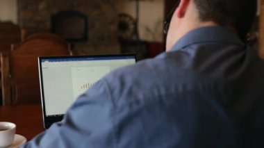 Kahve içme ve bir pasta yemeye not defterinde, notlar ve arama bilgi alarak konuşan bezgin yakışıklı genç işadamı bardaklarda dizüstü bilgisayar, çalışma. Çoklu görev telecomuting kavramı.