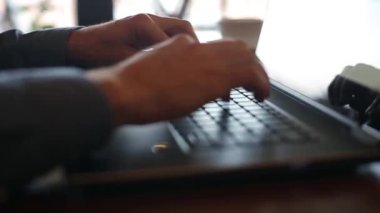 Serbest el laptop klavye ağır çekimde yazarak çevresinde kamera slaytlar. Office Internet ile çalışan iş adamı. Adam coffeeshop internet tarama. İş kavramı.