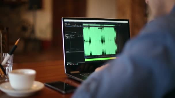 사운드 디자이너 또는 오디오 소프트웨어와 함께 화면에 파형을 마스터링 노트북에서 일 하는 엔지니어. Dj 사람 음악을 듣고입니다. 추적 및 샷 공개. — 비디오