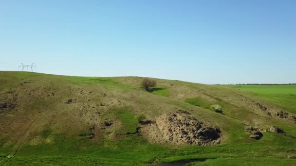 Images aériennes de la caméra volant au-dessus de la vallée pittoresque, des champs et des collines verdoyantes, des falaises et des montagnes rocheuses, du rondin et de la rivière. Printemps et été week-end à la nature concept . — Video