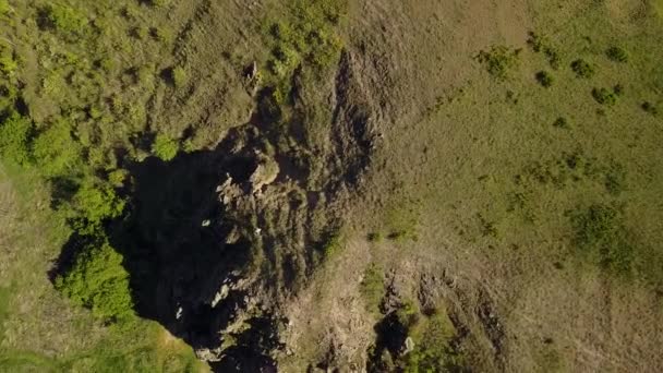 Flygfoto över mannen som kommer ner från berget. Manliga vandring ner rocky klippan ensam. Klättrare i bergen. Guy vandring i den natursköna gröna dalen. — Stockvideo