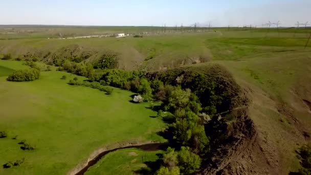 Übergang vom Elektrizitätswerk in eine grüne Tallandschaft mit Flüssen, Hügeln und Felsen. Antenne der elektrischen Energieanlage auf dem Land. Urbanisierung Umweltverträglichkeitskonzept. — Stockvideo