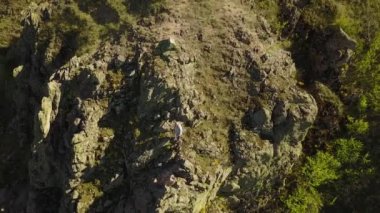 Havadan görünümü dağcı solo uçurumlarda yalnız tırmanma ücretsiz. Adam rock emniyet kemeri ve ipler olmadan tırmanmak. Erkek dağ ve sallanan el kamera için tırmandı.