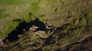 Dağdan gelen adam hava görünümünü. Erkek kayalık uçurum yalnız hiking. Dağcı dağlarda. Adam doğal yeşil vadide trekking.