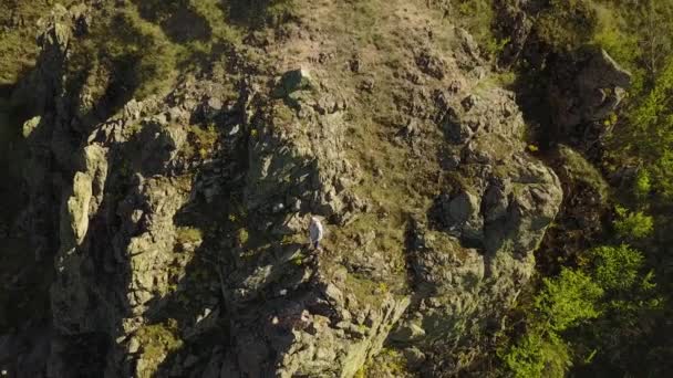 Vista aérea de escalador solo escalada libre en acantilados solo. Hombre subir a la roca sin arnés de seguridad y cuerdas. Hombre subió a la cima de la montaña y saludando mano a cámara . — Vídeo de stock