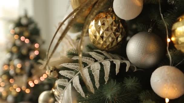 Interior de Natal branco elegante com abetos decorados, lareira, lanternas, lâmpadas, velas, grinaldas, solavancos e presentes. Conforto casa com árvore de natal cheia de decorações douradas, luzes e — Vídeo de Stock