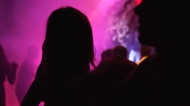 Мариуполь, Украина - 15 июня 2019 года. Люди танцуют в ночном клубе "Барбарис", освещенном огнями шоу. Силуэты мужчин и женщин, тусующихся на танцполе в замедленной съемке. Обычная вечеринка в выходные дни . — стоковое видео