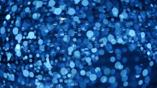 Abstract background with defocused bokeh balls for Christmas. New Year holidays backdrop with glittering lights of bulb garlands. Real lens blur of bright winter party lights at night. — Stock Video