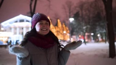 Genç bir kadın kış gecesi Noel pazarında kar yağarken eğleniyor. Parkta kar altında kollarını açıp kar tanelerini ellerinle, ağzınla yakala. Dişi kollarını gökyüzüne uzatıyor.