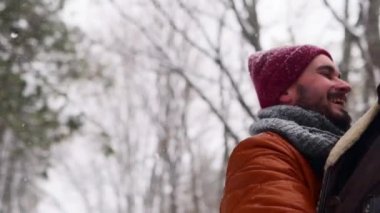 Dönen ya da mutlu bir kız arkadaşı döndüren bir adam çam ormanında kar yağışında onu elinde tutuyor. Sevgili çift, karlı kış parkında iyi eğlenceler. Sevgililer Günü ve Noel. Ağır çekimde gülen kadın.