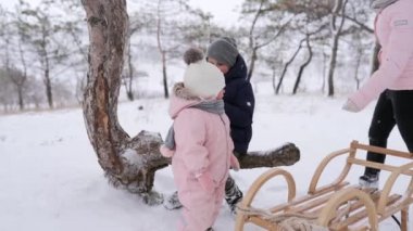 Tulumlu kız ve oğlan, karlı bir günde kızakla kaydıktan sonra iyi vakit geçiriyorlar. Erkek ve kız kardeş kış tatillerini birlikte geçirirler. Çocuk Noel çöreğiyle çay içiyor. Annem çocukları önemser..