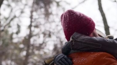 Dönen ya da mutlu bir kız arkadaşı döndüren bir adam çam ormanında kar yağışında onu elinde tutuyor. Sevgili çift, karlı kış parkında iyi eğlenceler. Sevgililer Günü ve Noel. Ağır çekimde gülen kadın.