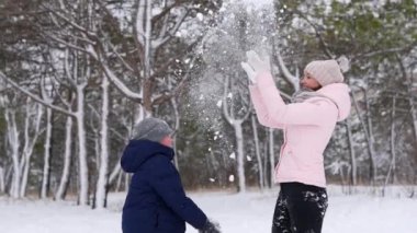 Mutlu anne ve oğul karla oynar ve soğuk kış gününde onu ormana fırlatırlar. Kadın ve çocuk şık kış kıyafetleri içinde orman parkında ilk karlı havanın tadını çıkarıyorlar. Yavaş çekim.