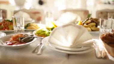 Kurumsal noel partisinde ya da düğün kutlamalarında güneşte aperatifleri ve yiyecekleri çok güzel servis edilen ziyafet masası. Beyaz iç dekorasyonla dekore edilmiş..