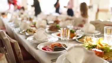 Kurumsal noel partisinde ya da düğün kutlamalarında güneşte aperatifleri ve yiyecekleri çok güzel servis edilen ziyafet masası. Beyaz iç dekorasyonla dekore edilmiş..