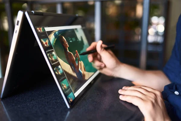 Freelancer retoucher man werkt op converteerbare laptop computer met foto-editing software met behulp van stylus. Fotograaf of ontwerper digitale kunstenaar beeldverwerking. 2 in 1 met touchscreen in tentmodus. — Stockfoto