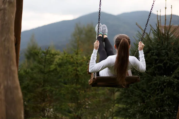 Fille chevauchant une balançoire avec montagne des Carpates sur le fond. Femme heureuse jouit et se détend sur ses vacances . — Photo