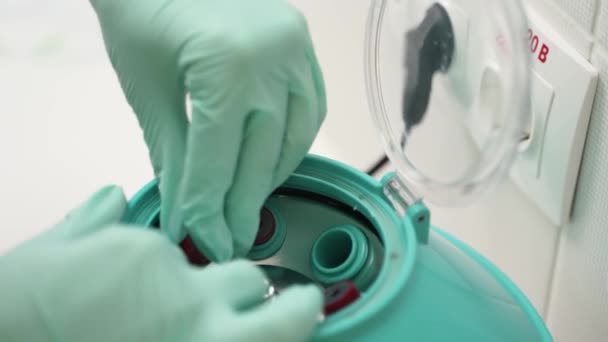 Доктор в рукавичках працює з пробірками крові для аналізу китайського коронавірусу. Вчений технік ставить ватажка в центрифугу. Дослідження епідемії ковадських вірусів та концепція розробки вакцин . — стокове відео