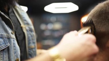 Son moda berber berber dükkanında sakallı adamın saçını kırpıcı ile kesiyor. Kuaförde erkek saç kesimi ve saç kesimi. Saçını budayarak mı? Kuaför retro kuaförde saç kesimi yapıyor..