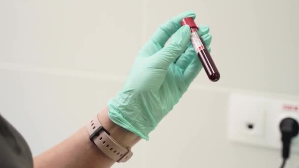Läkare i handskar skakar blodprovsrör för analys av kinesiskt coronavirus. Forskare tekniker rör steril vakuumvakt i laboratorium. Utveckling av vaccin mot Covid-virus, bioteknik. — Stockvideo