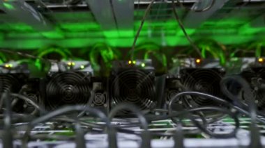 Büyük çiftlikteki kripto para madenciliği ekipmanları. ASIC madencileri sunucu odasında bitcoin 'i rafa kaldırıyor. Entegre devre engelleme teknolojisi uygulaması. Steadycam geri çekiliyor.