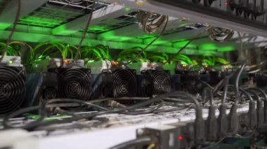 Büyük çiftlikteki kripto para madenciliği ekipmanları. ASIC madencileri sunucu odasında bitcoin 'i rafa kaldırıyor. Entegre devre engelleme teknolojisi uygulaması. Kaydırma kamerası.