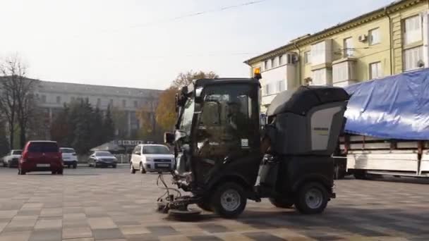 12 de março de 2020 - Mariupol, Ucrânia. varredor de rua carro limpeza cidade calçada pavimentação lajes com arruelas de pressão e vassouras rotativas ao ar livre. Detalhes da máquina de varredura de estrada . — Vídeo de Stock