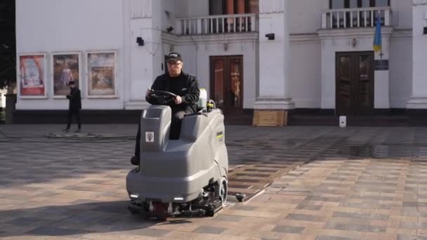 12 maart 2020 - Mariupol, Oekraïne. Straatveger auto reinigen stad stoep bestrating platen met drukreinigers en roterende bezems buiten. Details van de veegmachine. — Stockvideo