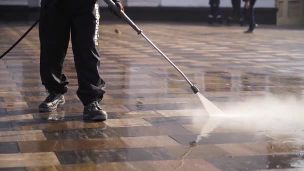 March, 12, 2020 - Mariupol, Ukraine. Street sweeper car cleaning city sidewalk paving slabs with pressure washers and rotating brooms outdoors. Road sweeping machine details. — Stock Video