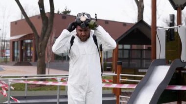 Koruyucu koruyucu koruyucu koruyucu koruyucu koruyucu giysi ve gaz maskesiyle virüs salgını sırasında poz veren tehlikeli madde temizleme işçisi. Solunum cihazına sprey sıkılmış kahraman fotoğrafı. Coronavirus, COVID-19.