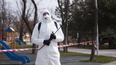 Tehlikeli madde temizleme işçisi virüs salgını sırasında koruyucu koruyucu koruyucu koruyucu koruyucu giysi ve yüz maskesi takıyor. Solunum cihazına sprey sıkılmış kahraman fotoğrafı. Coronavirus, COVID-19