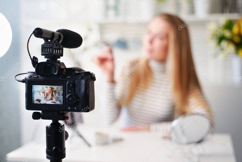 Display of camera recording video blog for blonde beauty blogger woman with make-up at home studio. Influencer vlogger girl live streaming cosmetics masterclass. Online learning and marketing concept.