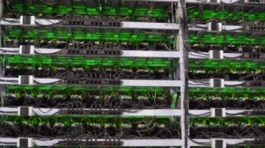 Büyük kablolu internet veri tabanı deposu. Büyük çiftlikteki kripto para madenciliği ekipmanları. ASIC madencileri sunucu odasında bitcoin 'i rafa kaldırıyor. Süper bilgisayar ışıklarla yanıp sönüyor. Üçayaklı panorama.