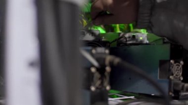 Bitcoin çiftliğindeki kripto para madencilik ekipman servisi. Teknisyen ASIC madencilerinin veri tabanı sunucu odasındaki askılarına ethernet kablo bağlayıcı yerleştiriyor. Engelleme zinciri donanım kurulumu.