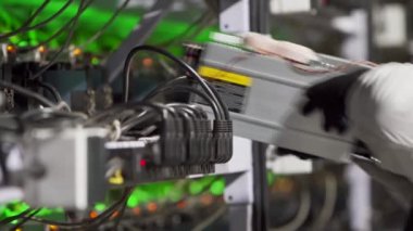 Veri merkezi tanı teknisyeni ASIC bitcoin madencisini rafa yerleştirir, ethernet kablosunu bağlar. Madencilik ekipman sunucu servisi. Yönetici çiftlik kripto para birimi hesaplama ağını onardı.