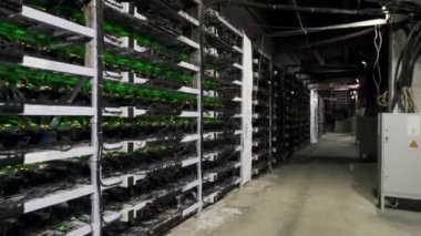 Büyük çiftlikteki kripto para madenciliği ekipmanları. ASIC madencileri sunucu odasında bitcoin 'i rafa kaldırıyor. Entegre devre engelleme teknolojisi uygulaması. Raflar boyunca sabit kamera görüntüleri.