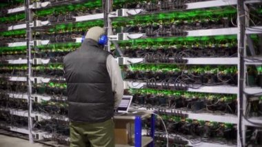 Veri merkezi tanı teknisyeni laptopta çalışır ve yazı yazar. Sunucu odasında madencilik ekipmanları servisi. Yönetici, ağ donanım denetim günlüğü ile hesaplama kümesini onarır.