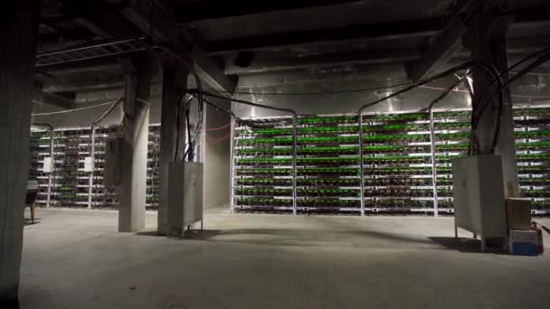 Großes kabelgebundenes Internet-Rechenzentrum. Kryptowährungsbergbaugeräte auf einem großen Bauernhof. ASIC-Minenarbeiter auf Standbrettern fördern Bitcoin im Serverraum. Supercomputer blinkt mit Lichtern. Stativpanorama.