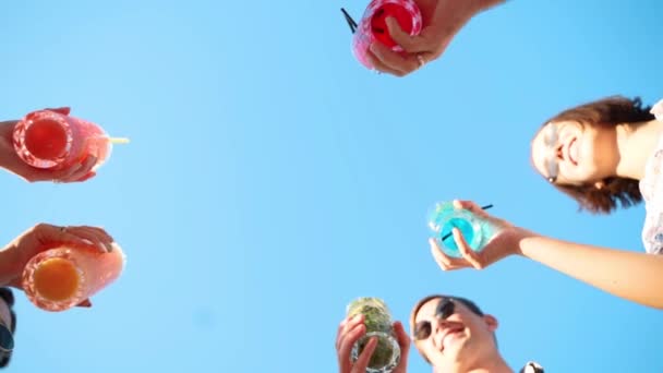 Laag uitzicht op vrienden die plezier hebben op het zwembadfeest, klinkende glazen met kleurrijke zomercocktails in de buurt van het zwembad van het hotel. Mensen toasten op vers sap in luxe zomervilla in slow motion. — Stockvideo