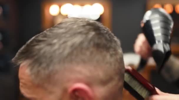 Attraktives Friseurmädchen, das mit Schere und Kamm seine Haare schneidet. Friseurinnen arbeiten im Kundendienst. Stilvoller Mann sitzt im Stuhl eines Friseursalons. Friseurin macht trendigen Haarschnitt. — Stockvideo