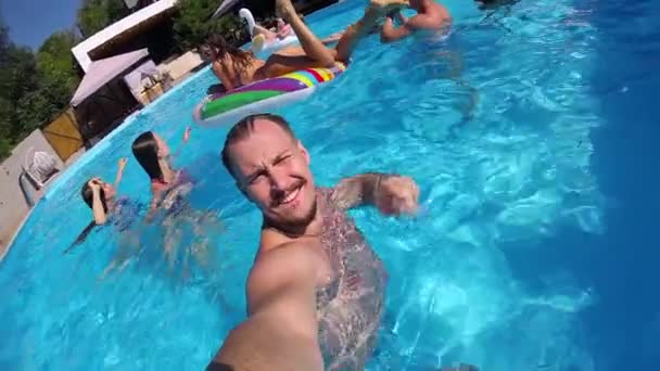 Lifestyle blogger muž s selfie video s akční kamerou v bazénu. Cestovní vlogger filmy vlog z párty v luxusním resortu. Fitted chlap živě streaming pro sociální média rád. Zpomalený pohyb. — Stock video
