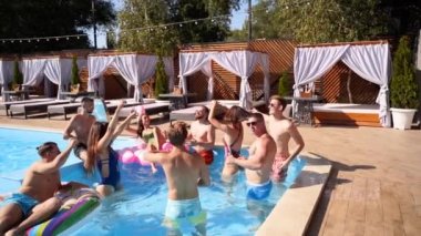 Çok ırklı bir arkadaş grubu özel bir villa havuzunda parti veriyor. Mayolu mutlu gençler dans ediyor ve lüks otellerde şişme flamingo, kuğu ve şilte takılıyor. Yavaşla.